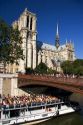 A boat tour on the river seine passes the Norte Dame cathedral in Paris, France.