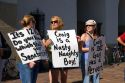 Women hold signs protesting Idaho Senator Larry Craig in Boise, Idaho.