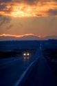Cars travel at sunset on highway 20 near Idaho Falls, Idaho.