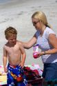 Mother applying sunscreen to her son at the beach in St. Petersburg, Florida. MR
