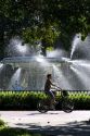 Bicyclist rides past a large fountain in Forsyth Park in the historic district of Savannah, Georgia.