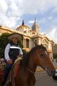 A police officer wearing a sombrero on horseback in front of the Palace of Fine Arts in Mexico City, Mexico.