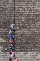 Tourists walk down steps using a railing on the Pyramid of the Moon at Teotihuacan in the State of Mexico, Mexico.