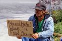 Homeless man holding a sign.