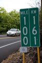 Roadside mile marker showing measurement in miles and kilometers on the Big Island of Hawaii.