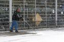 Man shoveling snow in front of a business in Boise, Idaho.