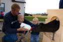 Farmer and his boys feed a dairy calf with a bottle on a farm in Utah.