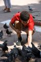 Young man feeding pigeons in Buenos Aires, Argentina.