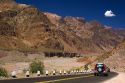 Vehicles drive on a highway along the Mendoza River in the Andes Mountain Range west of Upsallata, Argentina.