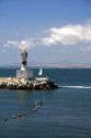 Small lighthouse and sailboat on the Pacific Ocean at Concon, Chile.