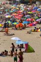 People sit under umbrellas for shade on the beach at Concon, Chile.