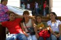 Chilean family sitting on a bench in the Plaza de Armas in Santiago, Chile.