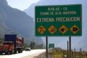 Spanish language road sign warning of hazardous road conditions at the foot of the Andes Mountain Range in Chile.