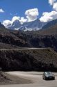 A car drives on switchback roads through the Andes Mountain Range in Chile.