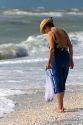 Beachcomber searching for seashells on the beach at Sanibel Island on the Gulf Coast of Florida.
