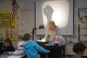 Fourth grade elementary school teacher using an overhead projector in a classroom in Tampa, Florida.
