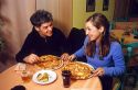 Young couple dines on pizza in a restaurant at Sirmione, a comune in the province of Brescia, Lombardy, Italy.