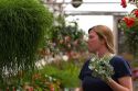 Woman making a funny face trying to decide on purchasing a plant in the greenhouse of a nursery in Nampa, Idaho. MR