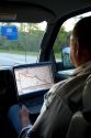 Passenger in a moving vehicle using GPS navigation on a laptop in Michigan. MR