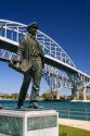 A statue of Thomas Edison by local artist Mino Duffy sits below the Blue Water Bridge along the St. Clair River at Port Huron, Michigan.