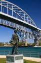 A statue of Thomas Edison by local artist Mino Duffy sits below the Blue Water Bridge along the St. Clair River at Port Huron, Michigan.