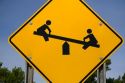 Road sign depicting a seesaw, waring of children playing in Gratiot County, Michigan.