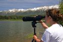 Wildlife biologist using a telescope to view nesting loons at Summit Lake, Montana.