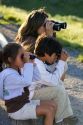 Hispanic family viewing wildlife with binoculars in Yellowstone National Park, Wyoming. MR