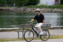 Asian man riding a bicycle at Stanley Park in Vancouver, British Columbia, Canada.