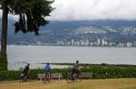 Bicyclists ride along the Seawall path in Staney Park at Vancouver, British Columbia, Canada.