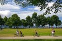 Bicyclists ride along the Seawall path in Stanley Park at Vancouver, British Columbia, Canada.