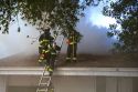 Firefighters fight a house fire on the roof in Boise, Idaho.