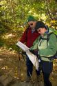 Hikers reading a map on a trail to Mount Lafayette at the northern end of the Franconia Range in the White Moutain National Forest, New Hampshire, USA.