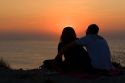 Couple watching the sunset over the Atlantic Ocean at Saint-Jean-de-Luz, Pyrenees Atlantiques, French Basque Country, Southwest France.