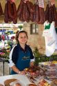 Spanish woman selling cured meats at an outdoor market in the town of Cangas de Onis, Asturias, northern Spain.