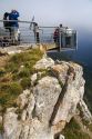 Visitors stand on a platform overlooking the Picos de Europa at Fuente De, Liebana, Cantabria, northwestern Spain.