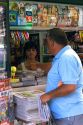 Man purchasing a newspaper from a newsstand in the town of Llanes, Asturias, Spain.