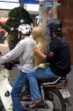 Vietnamese men ride a motorbike with a mannequin in Ho Chi Minh City, Vietnam.