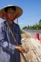 Vietnamese farmers drying peanuts along side the road in the Cu Chi district of Ho Chi Minh City, Vietnam.