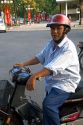 Vietnamese man riding a motorbike in Ho Chi Minh City, Vietnam.