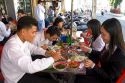 Vietnamese office workers eat lunch at a sidewalk cafe in Ho Chi Minh City, Vietnam.