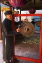 Monk sounding a gong at a temple in Hoi An, Vietnam.