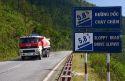 Fuel truck traveling past a grade warning road sign along the Hai Van Pass in Thua Thien-Hue Province, Vietnam.