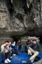 Tourists ride on a small boat viewing sea caves in Ha Long Bay, Vietnam.