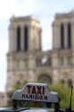 Sign atop a taxicab in front of the Notre Dame de Paris, France.