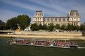Excursion boat passing by the Hotel de Ville along the river Seine in Paris, France.