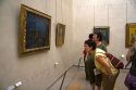 Visitors view artwork displayed in the Musee d'Orsay, Paris, France.