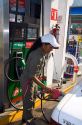 Mexican female attendant pumping fuel at a full service gas station in Acapulco, Guerrero, Mexico.