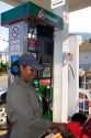 Mexican female attendant pumping fuel at a full service gas station in Acapulco, Guerrero, Mexico.