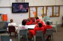 Inmates watch television in the recreational area of a county jail.
